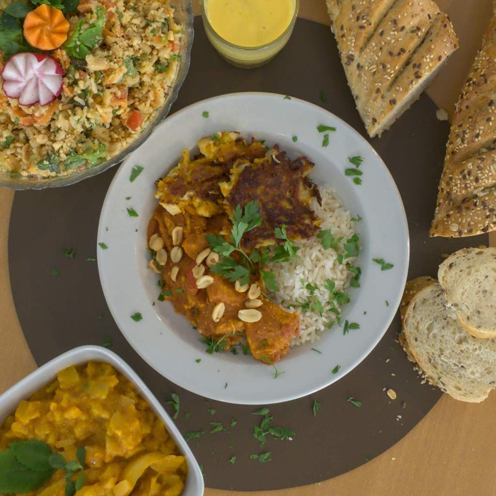 Hübsch angerichtetes Essen auf einem Teller, Eine Schale mit Salat, Brot und ein Dipp